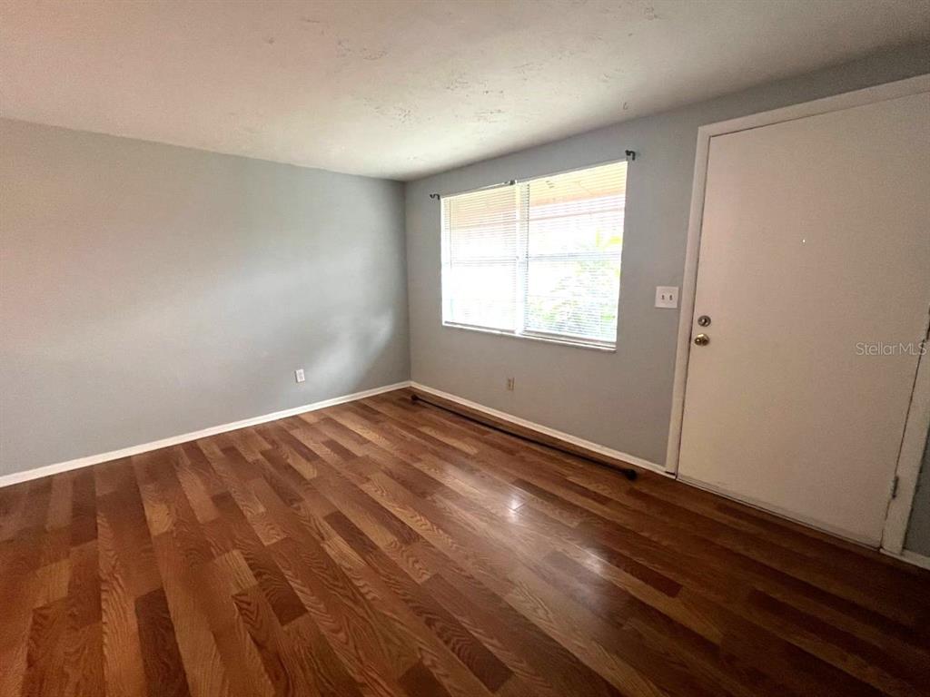 9406 Eastfield Road, Unit C Thonotosassa, FL 33592 - Photo 4 of 16 an empty room with wooden floor and windows