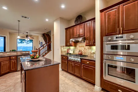 a kitchen with stainless steel appliances granite countertop a stove and a refrigerator