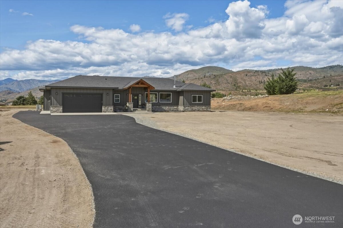 110 Slide View Lane Manson, WA 98831 - Photo 2 of 38 an outdoor view of house with yard and mountain view in back