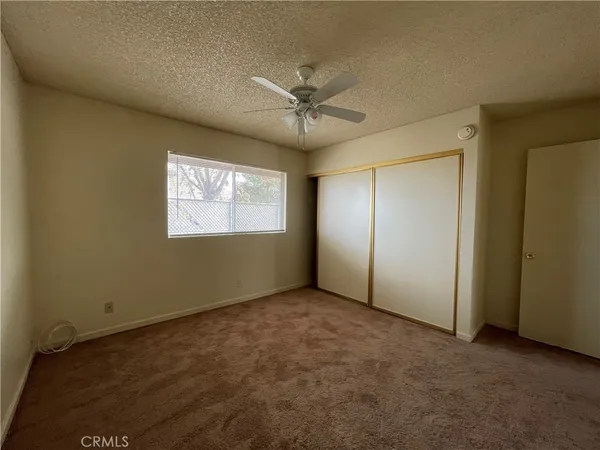 an empty room with windows and fan