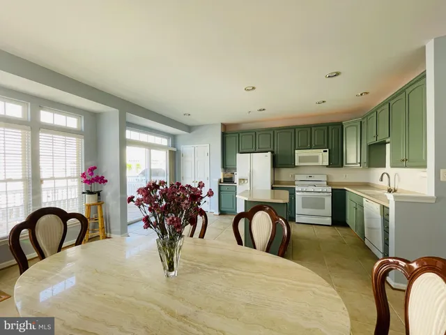 a living room with furniture a chandelier and kitchen view