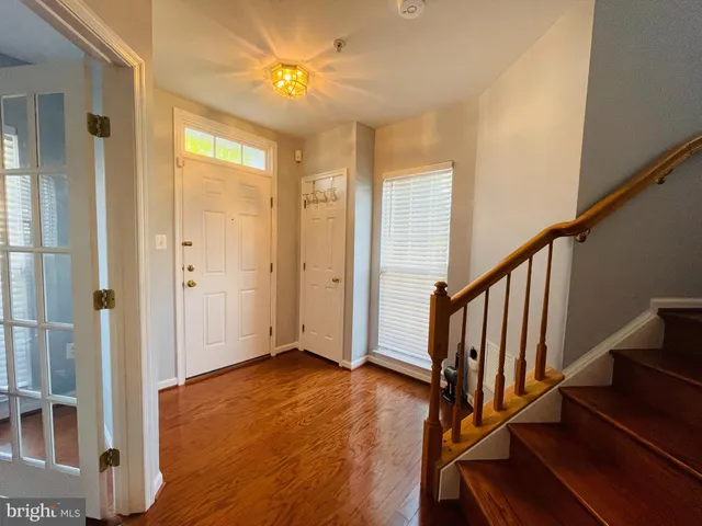 a view of an entryway with wooden floor and staircase