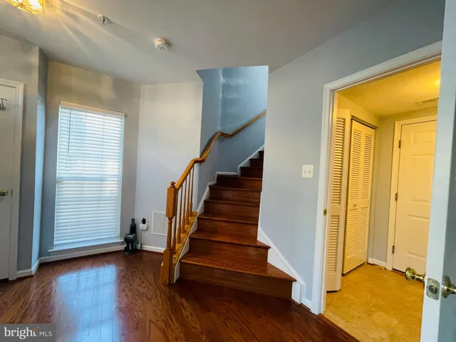 a view of front door with wooden floor and stairs