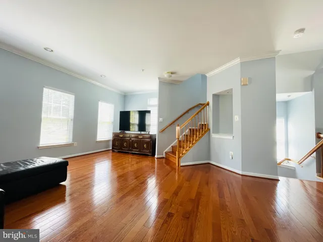a view of a livingroom with wooden floor and a ceiling fan