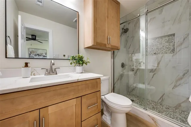 a bathroom with a sink vanity mirror and toilet
