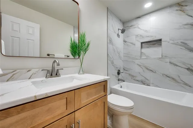a bathroom with a granite countertop sink toilet and shower