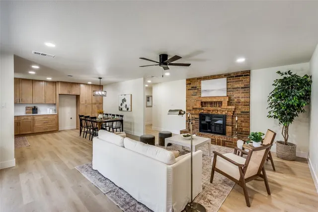 a living room with furniture kitchen view and a potted plant