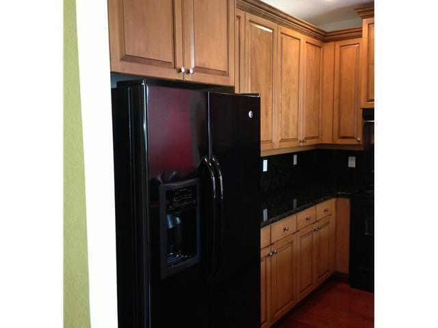 4127 Sandy Spit Lane Jupiter, FL 33458 - Photo 7 of 24 a kitchen with a refrigerator and cabinets