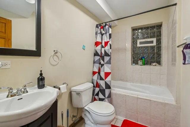 a white toilet sitting next to a bathroom sink and tub