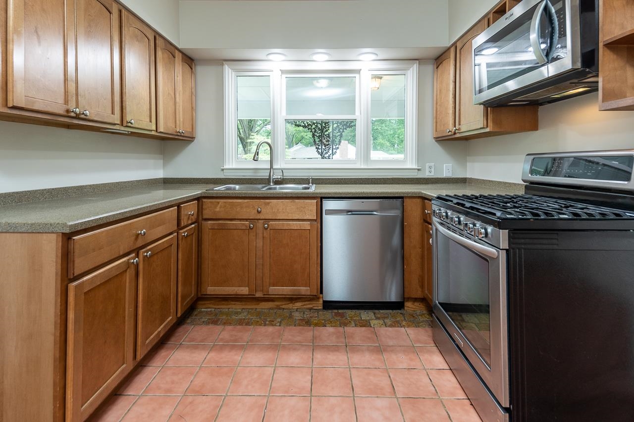 1004 South Perkins Road Memphis, TN 38117 - Photo 13 of 19 a kitchen with stainless steel appliances granite countertop a stove a sink and a microwave