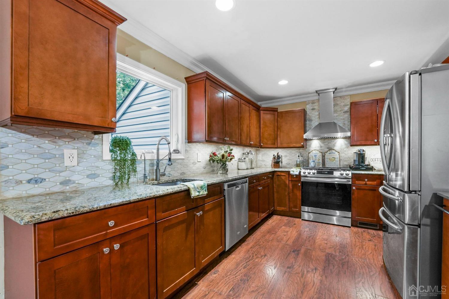 14 Baxter Road Edison, NJ 08817 - Photo 13 of 39 a kitchen with granite countertop wooden floors wooden cabinets a sink and appliances