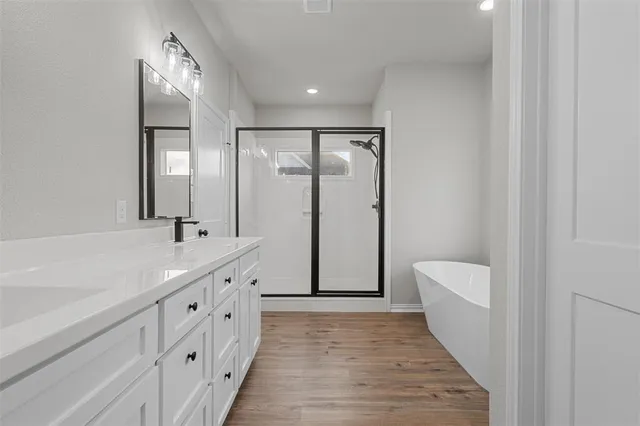 a bathroom with double vanity and a mirror