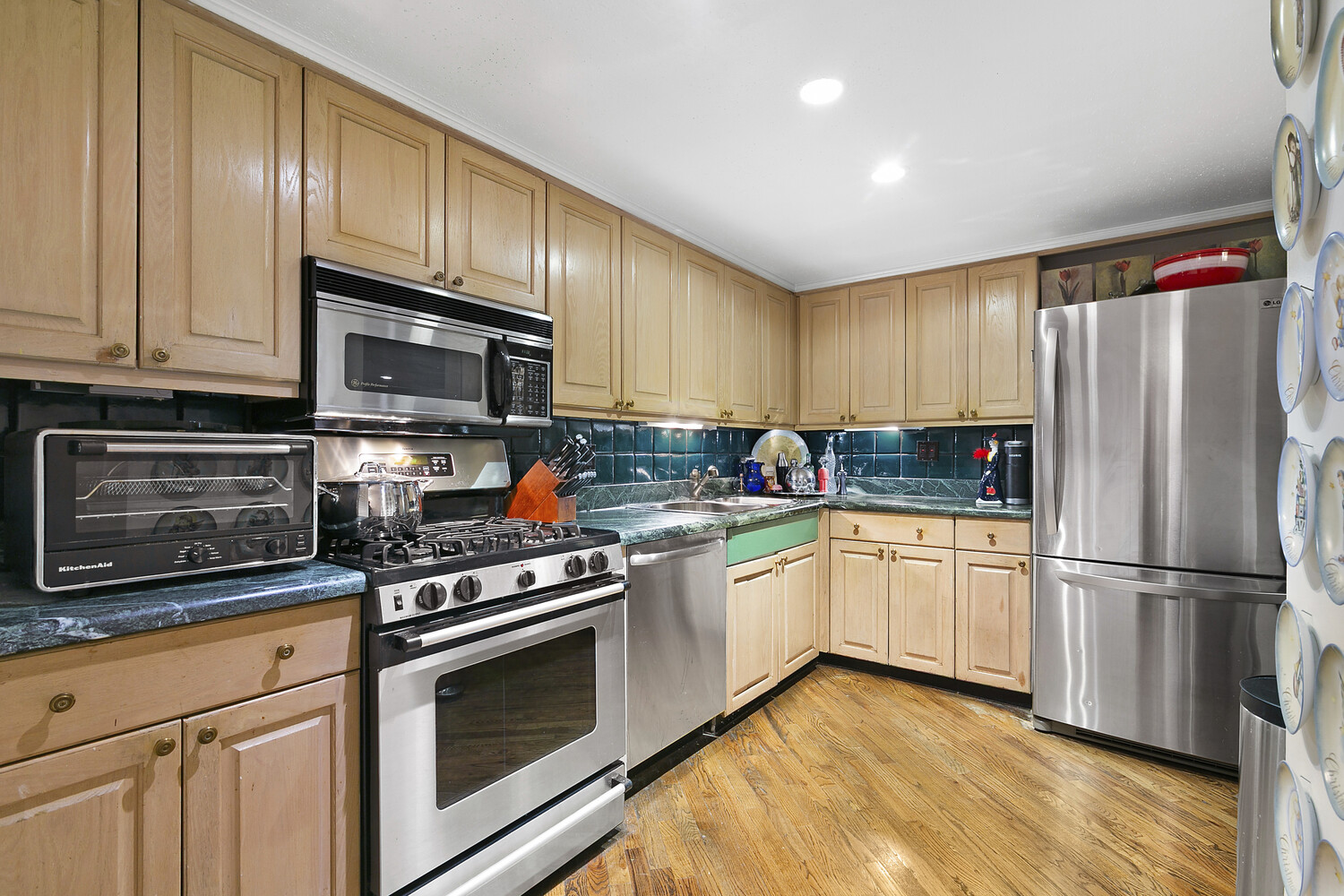 121 West 20th Street, Unit 2D Manhattan, NY 10011 - Photo 5 of 13 a kitchen with granite countertop wooden cabinets stainless steel appliances and a window