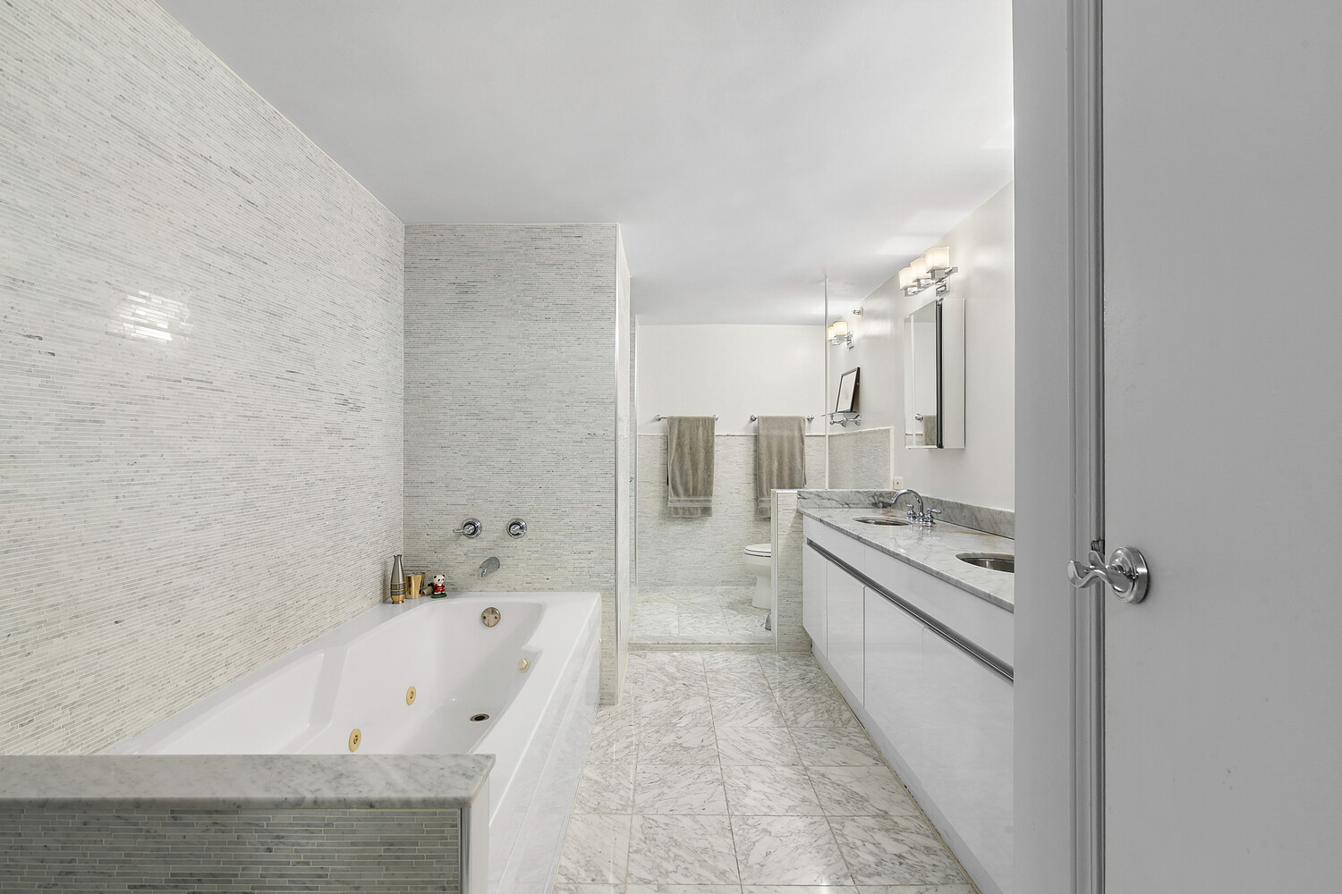 121 West 20th Street, Unit 2D Manhattan, NY 10011 - Photo 8 of 13 a large bathroom with a tub a sink and a large mirror