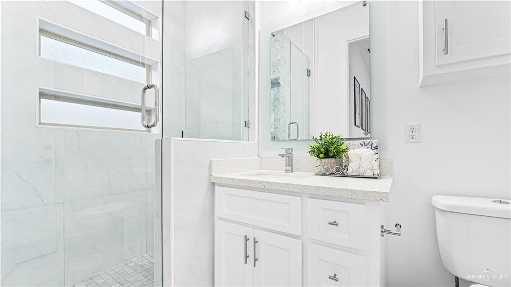 1505 Duke Street Mission, TX 78572 - Photo 26 of 39 a bathroom with a sink a toilet and a mirror