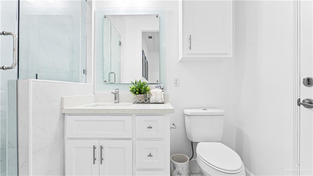 1505 Duke Street Mission, TX 78572 - Photo 27 of 39 a bathroom with a sink a toilet and vanity