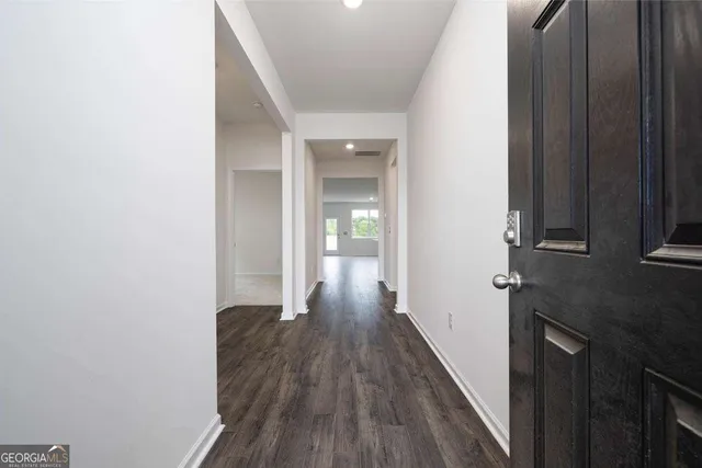 a view of an empty room with a ceiling fan and wooden floor