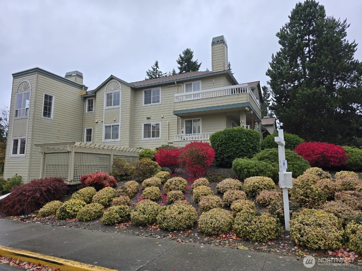 7207 210th Street Southwest, Unit 102 Edmonds, WA 98026 - Photo 1 of 14 a front view of a house with a yard and a garden