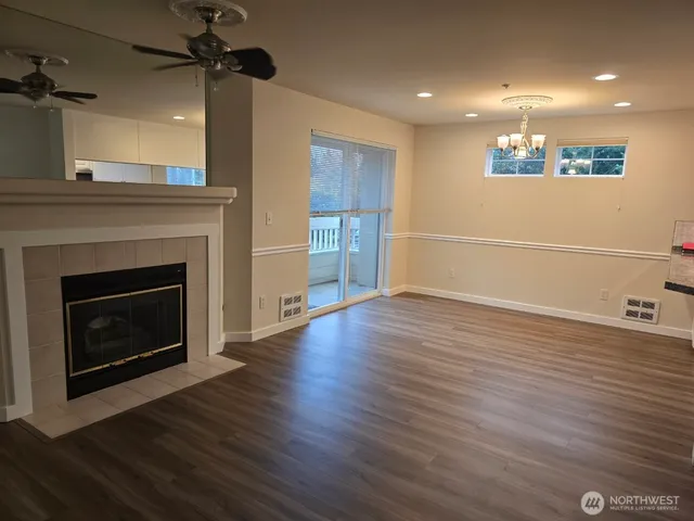 a view of a livingroom with wooden floor a fireplace and window