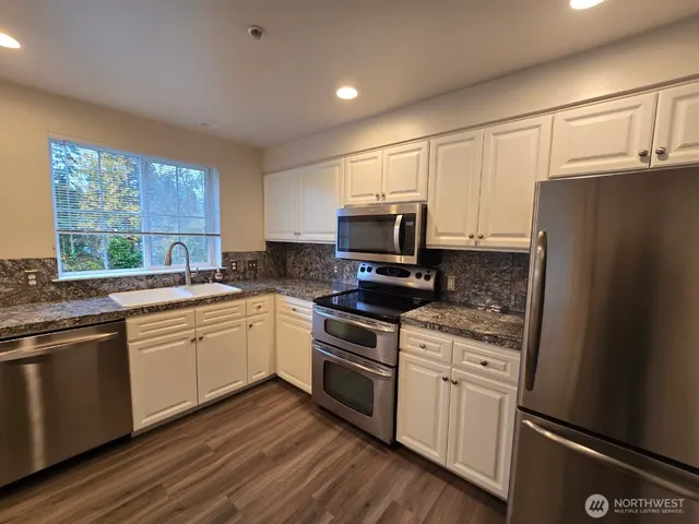 a kitchen with a sink stove and microwave