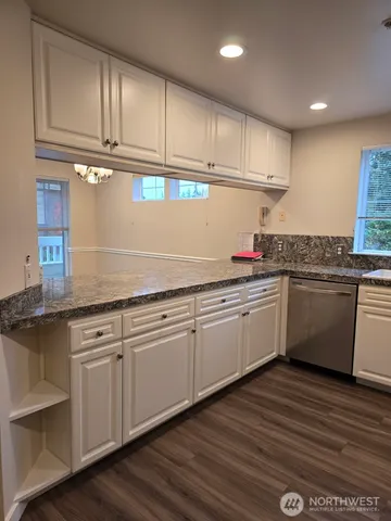 a kitchen with granite countertop cabinets stainless steel appliances and a sink
