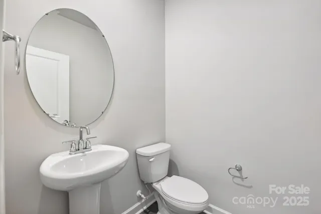 a bathroom with a toilet a sink and a mirror