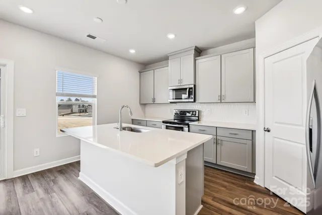 a kitchen with appliances a sink and cabinets