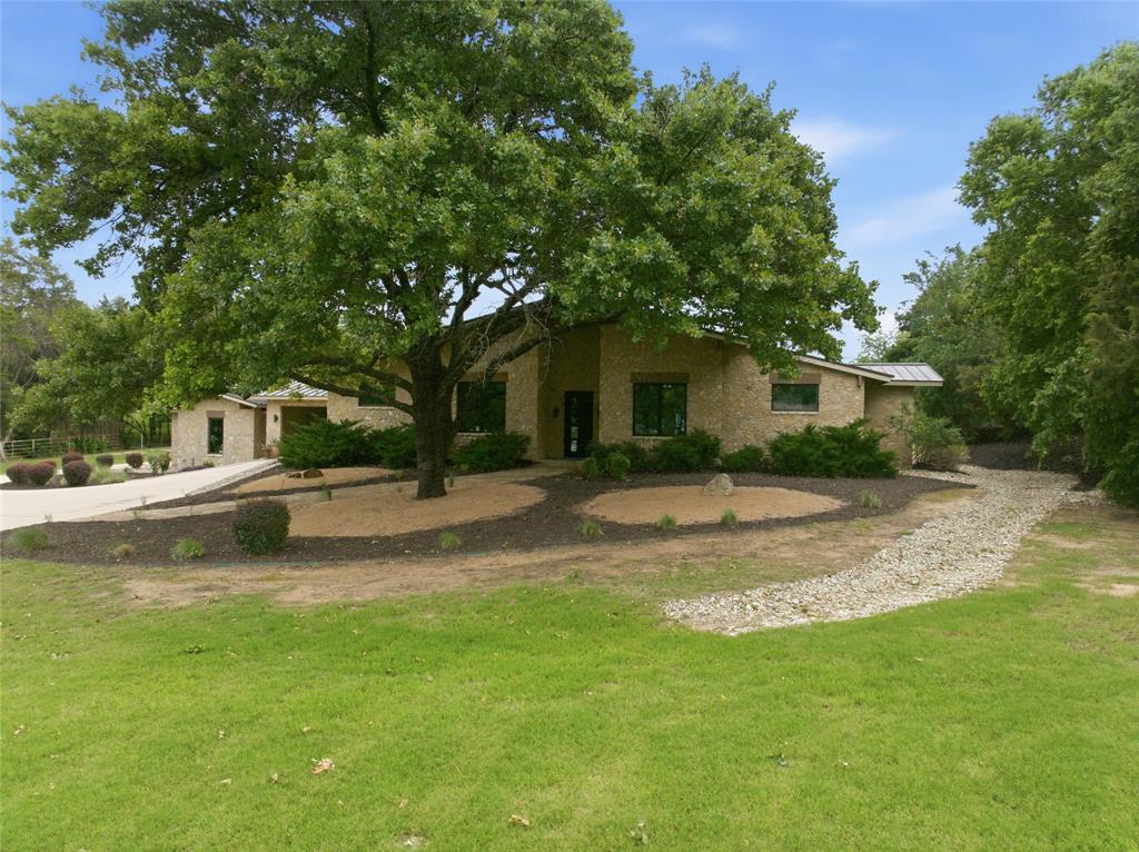 Stone exterior residence with a prominent mature tree