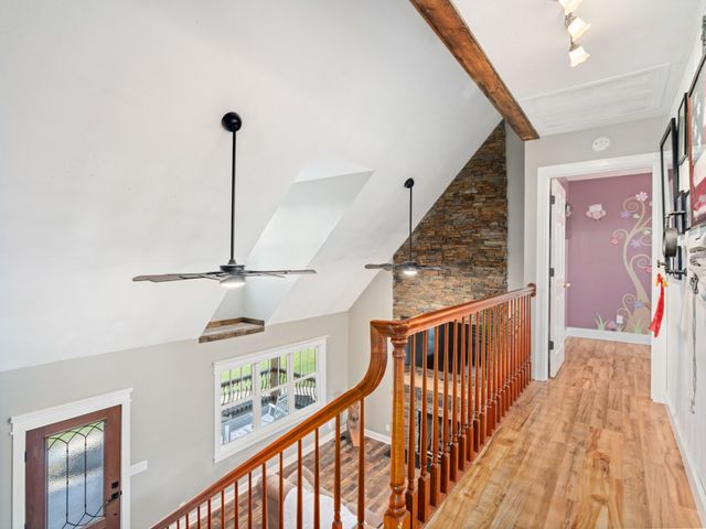a view of a hallway with wooden floor and stairs