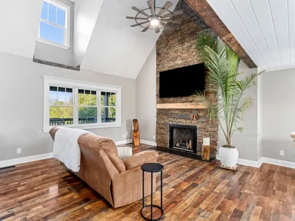 a living room with furniture a fireplace and a flat screen tv
