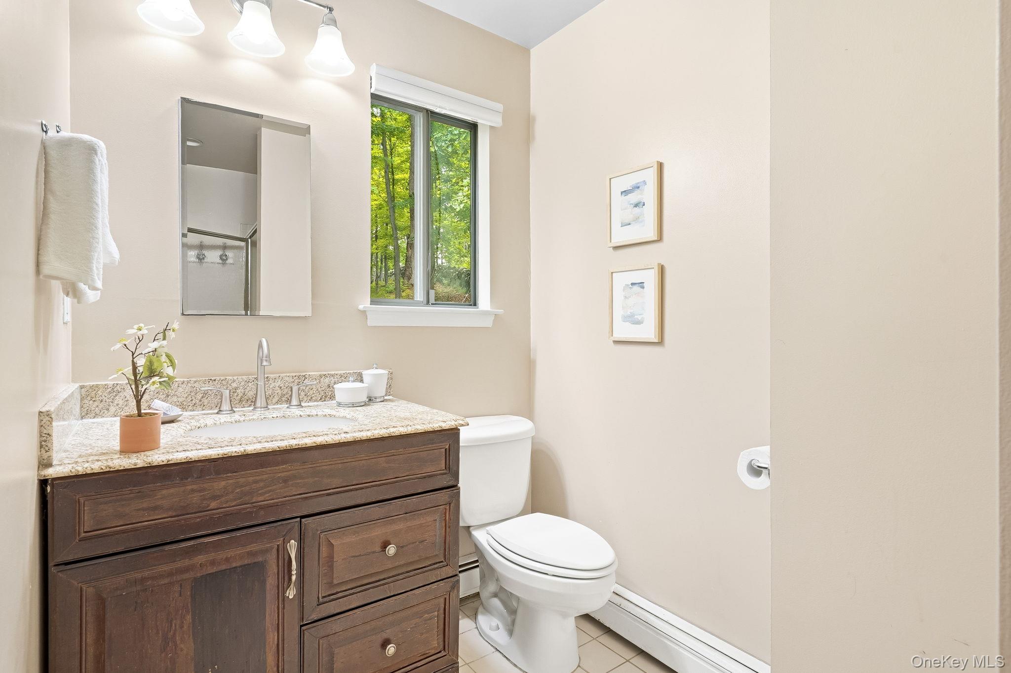 43 Powder Horn Road Cortlandt Manor, NY 10567 - Photo 16 of 35 Primary bathroom featuring a wood-finish vanity with granite-style countertop, undermount sink, and chrome-finish faucet
