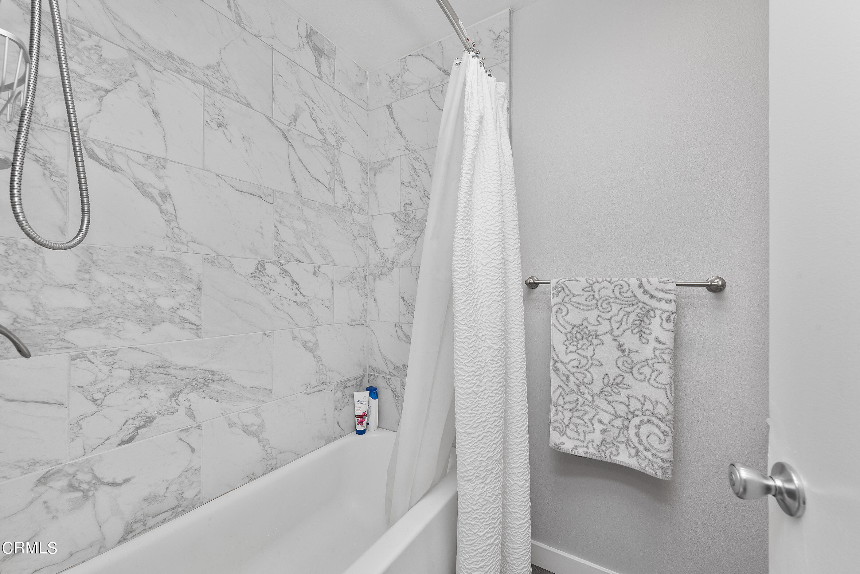 1718 Sinaloa Road, Unit 220 Simi Valley, CA 93065 - Photo 20 of 35 a bathroom with a shower curtain and a bathtub
