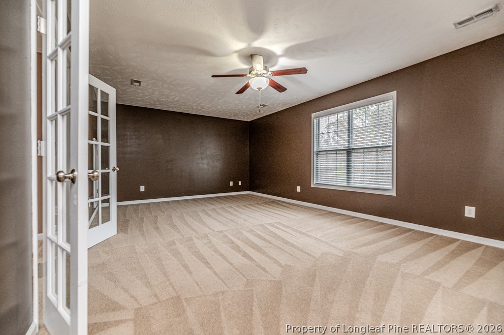 445 Hayden Lane Cameron, NC 28326 - Photo 39 of 49 an empty room with windows and ceiling fan