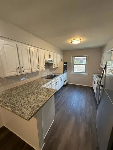 a kitchen with stainless steel appliances granite countertop a sink stove and wooden floor