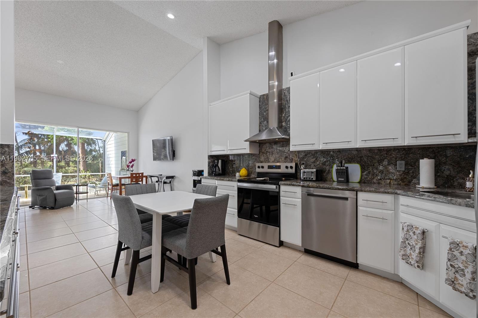 8962 Southeast Riverfront Terrace Jupiter, FL 33469 - Photo 2 of 20 a kitchen with stainless steel appliances kitchen island granite countertop a sink and cabinets