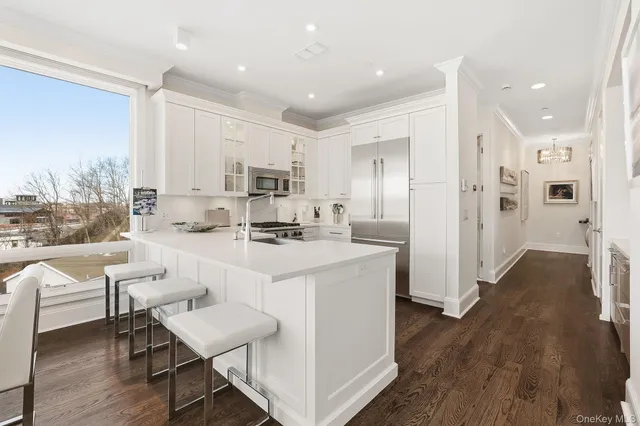 a kitchen with white cabinets and refrigerator