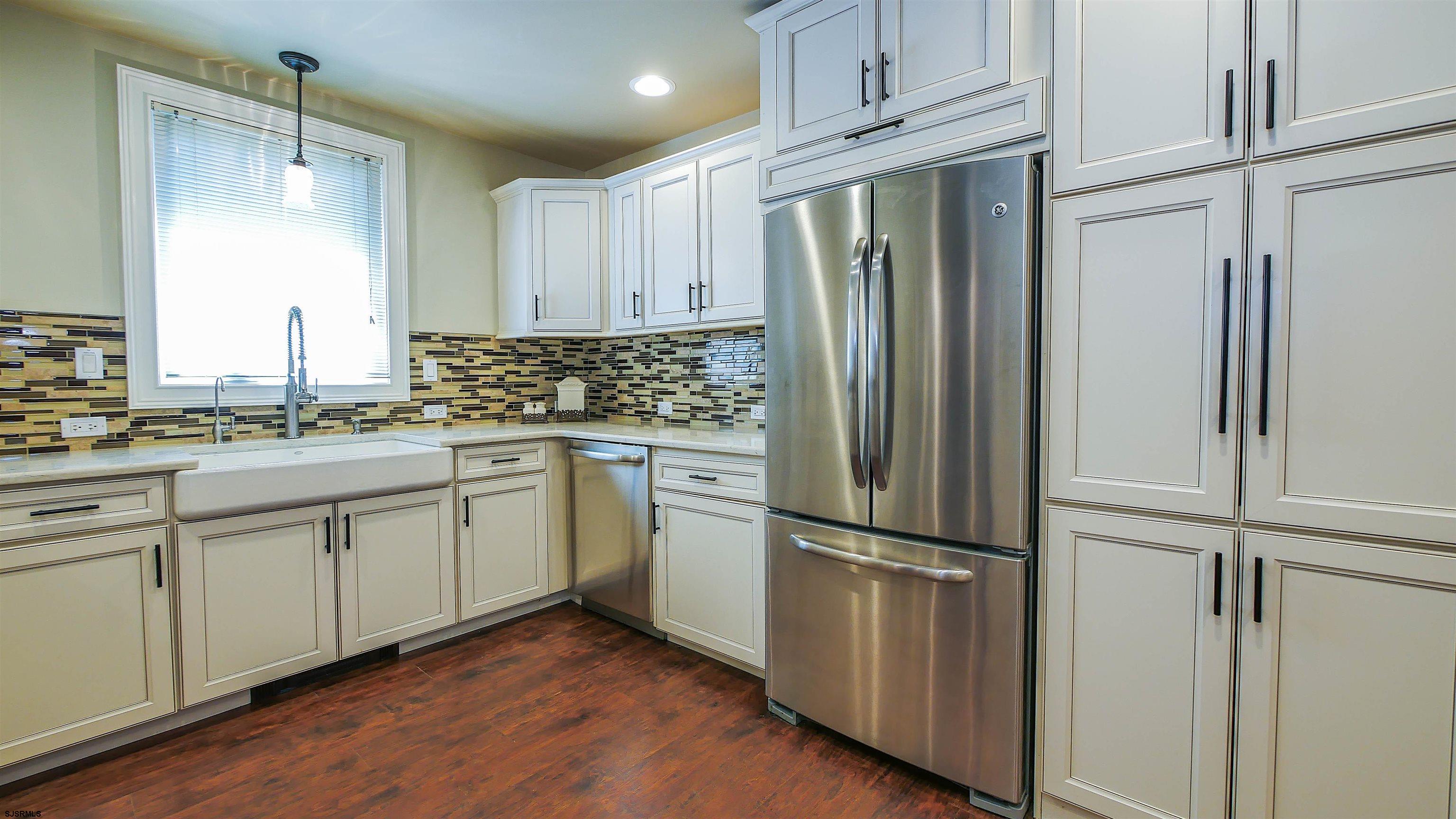 810 East Moss Mill Road Leeds Point, NJ 08205 - Photo 12 of 36 a kitchen with white cabinets stainless steel appliances and a refrigerator