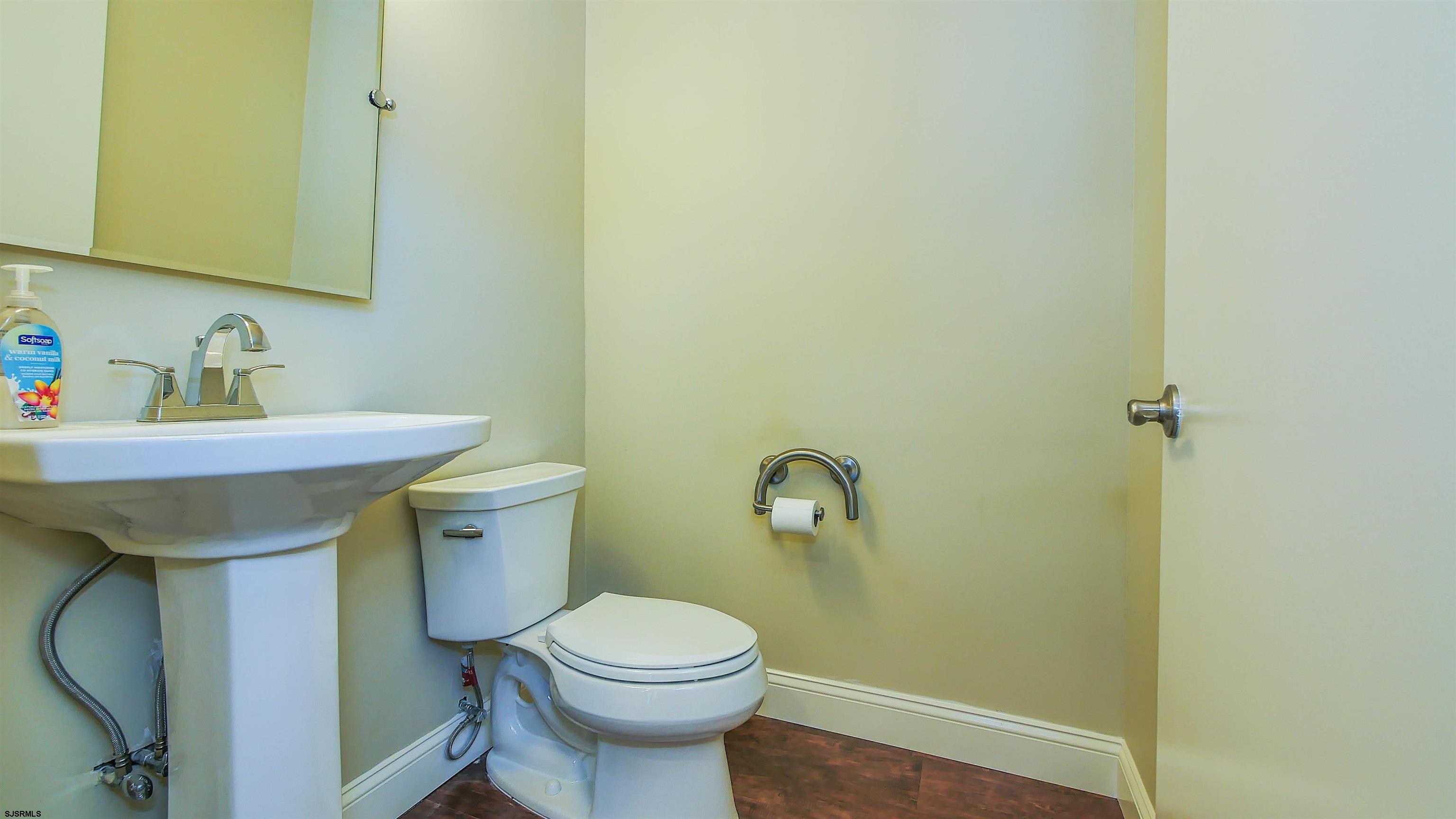 810 East Moss Mill Road Leeds Point, NJ 08205 - Photo 16 of 36 a bathroom with a sink a toilet and a mirror