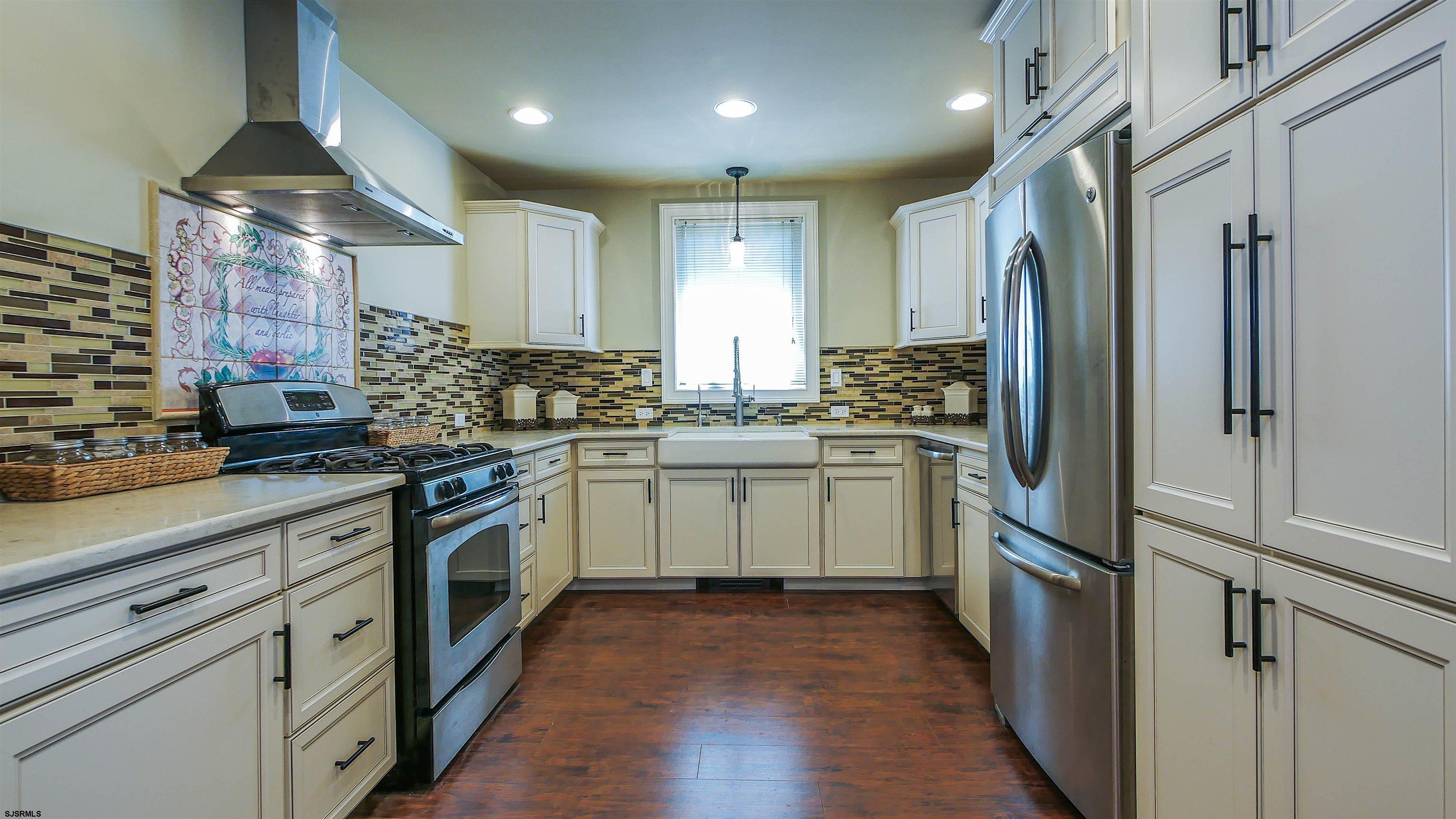 810 East Moss Mill Road Leeds Point, NJ 08205 - Photo 9 of 36 a kitchen with white cabinets and stainless steel appliances