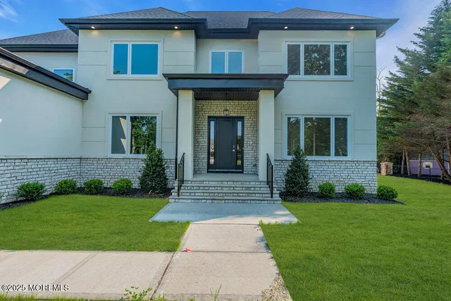 a kitchen with stainless steel appliances granite countertop a refrigerator oven a sink dishwasher and white cabinets with wooden floor