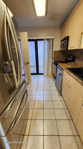 a kitchen with stainless steel appliances granite countertop a refrigerator and a stove