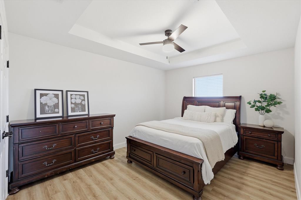 430 Ridgecrest Place Sanger, TX 76266 - Photo 19 of 40 Bedroom featuring a tray ceiling with a ceiling fan, wood-finish flooring, and a window with blinds