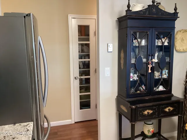 a view of a hallway with wooden floor and windows