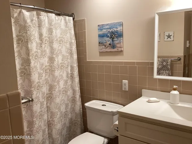 a bathroom with a sink a toilet and a shower curtain