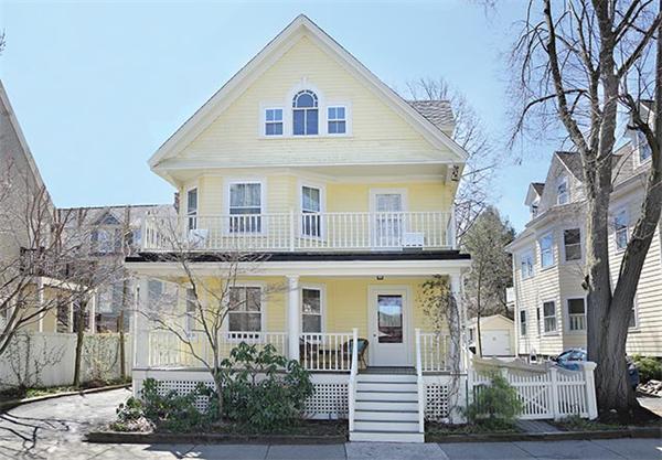a view of a white house with large windows and a small yard