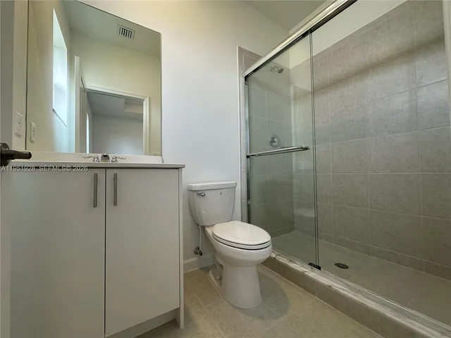 a bathroom with a shower a toilet and a sink