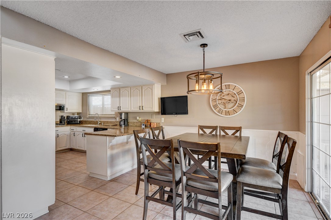 659 Arrayo Way Boulder City, NV 89005 - Photo 8 of 29 An inviting dining space with tiled floors connects seamlessly to the adjacent open kitchen.