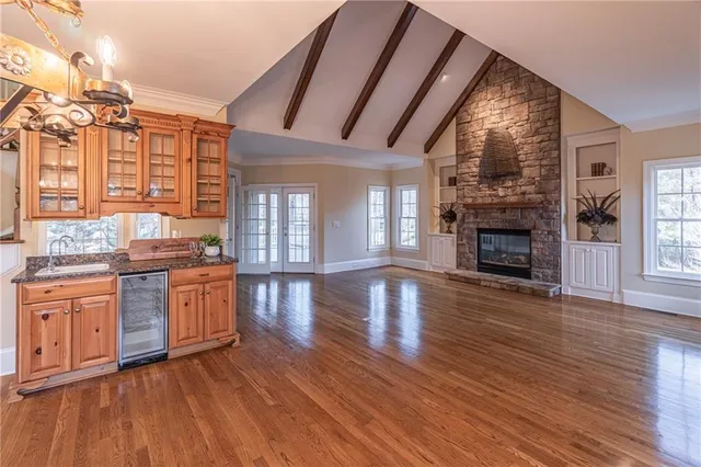 a open kitchen with granite countertop a stove top oven a sink dishwasher and a fireplace with wooden floor