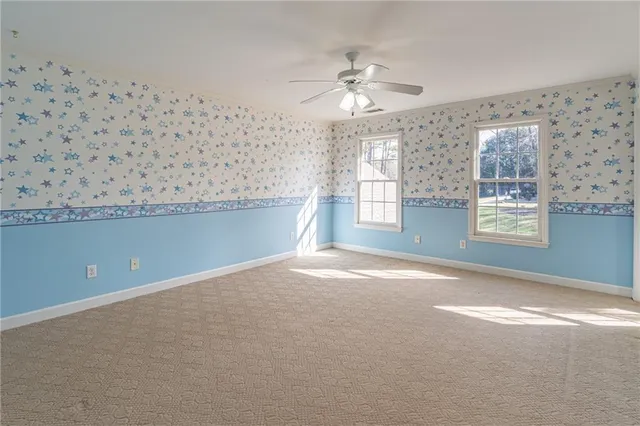 a view of a livingroom with a chandelier fan and windows