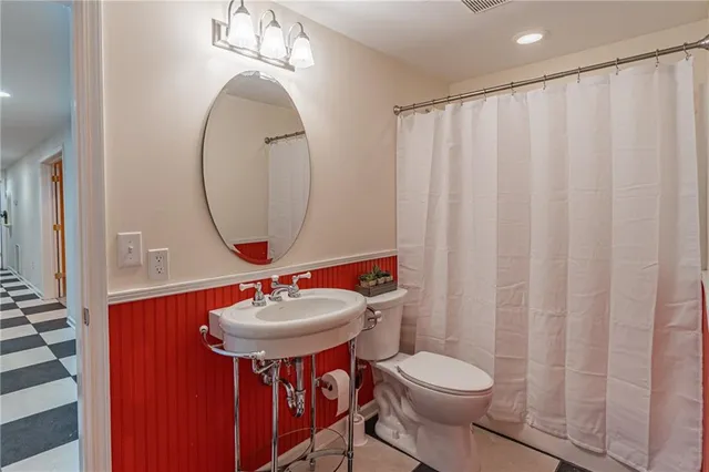 a bathroom with a toilet sink and mirror